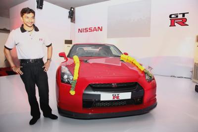 Padmashri Narain Karthikeyan standing alongside his new Nissan GTR which was handed over to him at an event in Chennai